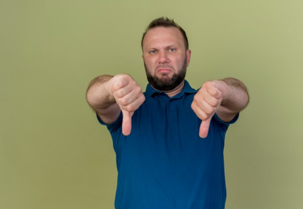 A guy doing a thumbs down sign 